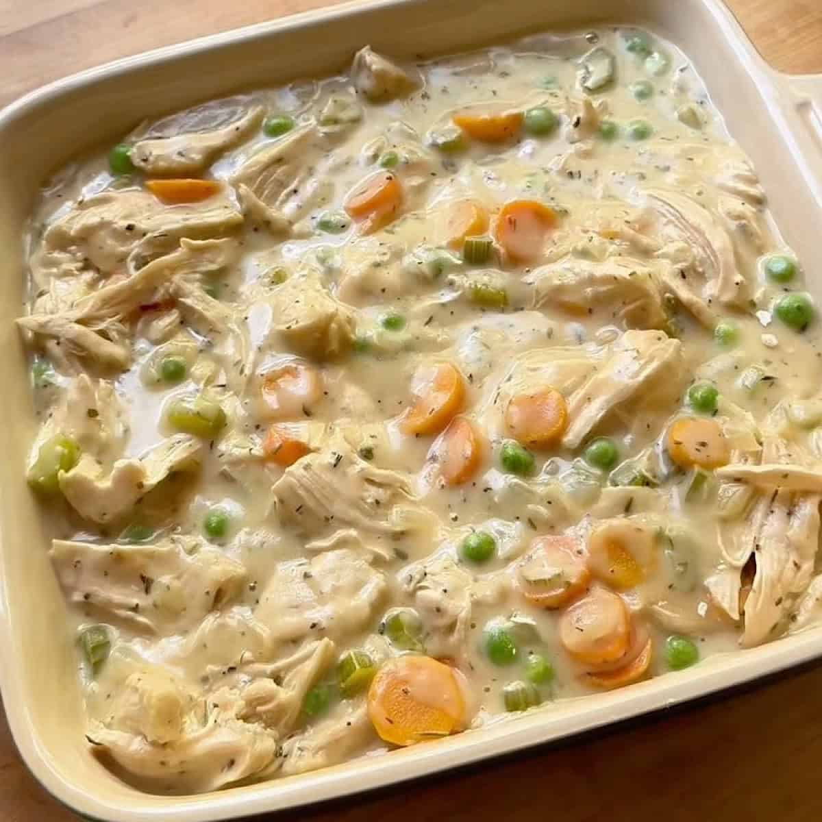 Chicken pot pie filling in an 8x8 casserole dish.
