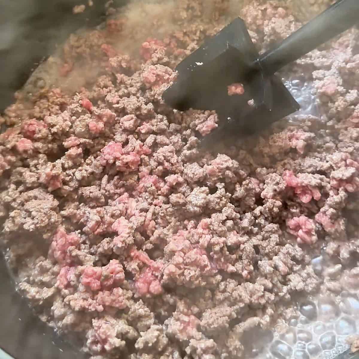 Ground beef browning in a dutch oven.