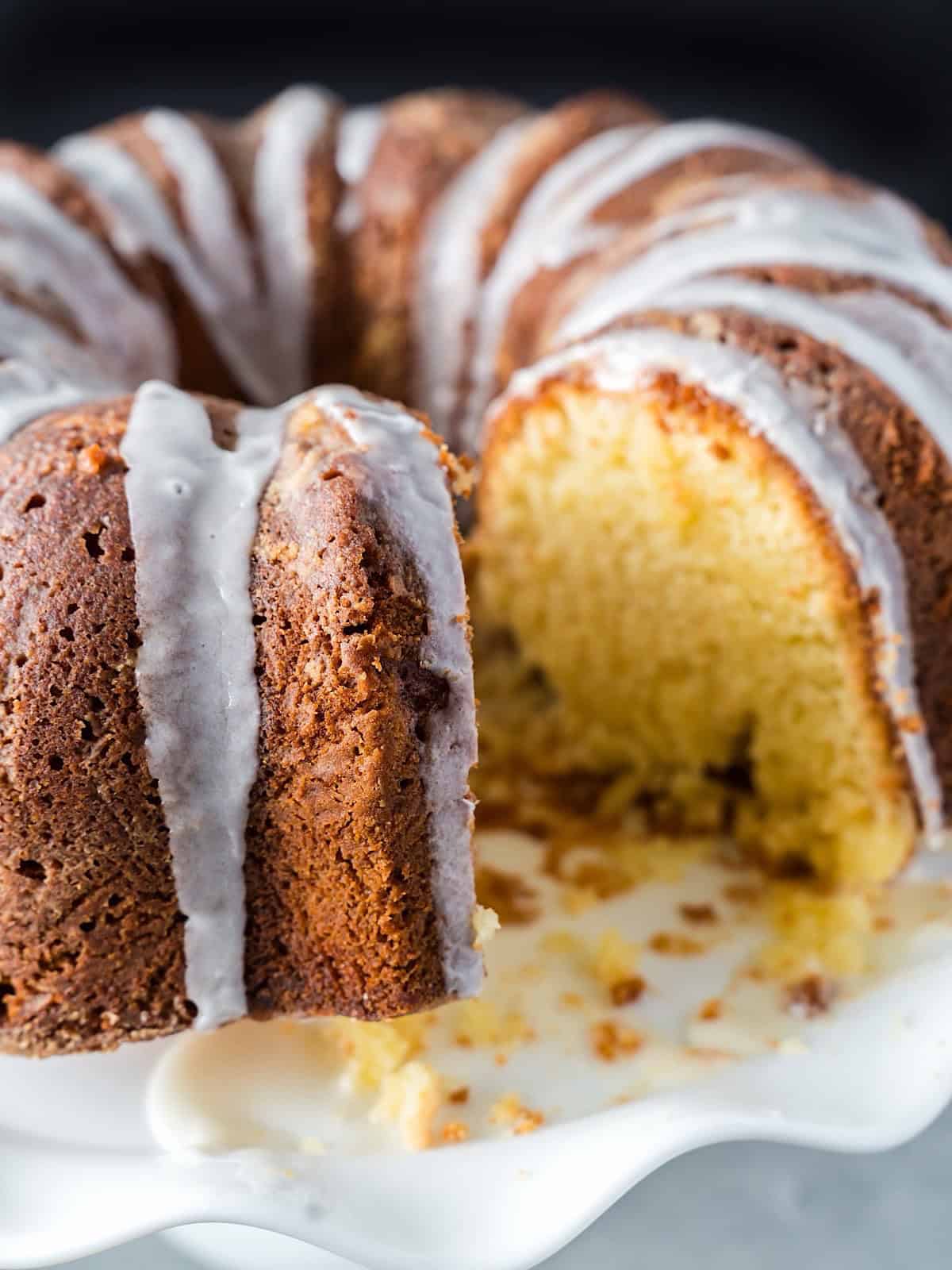 Southern pound cake on a standing cake platter with a slice removed.
