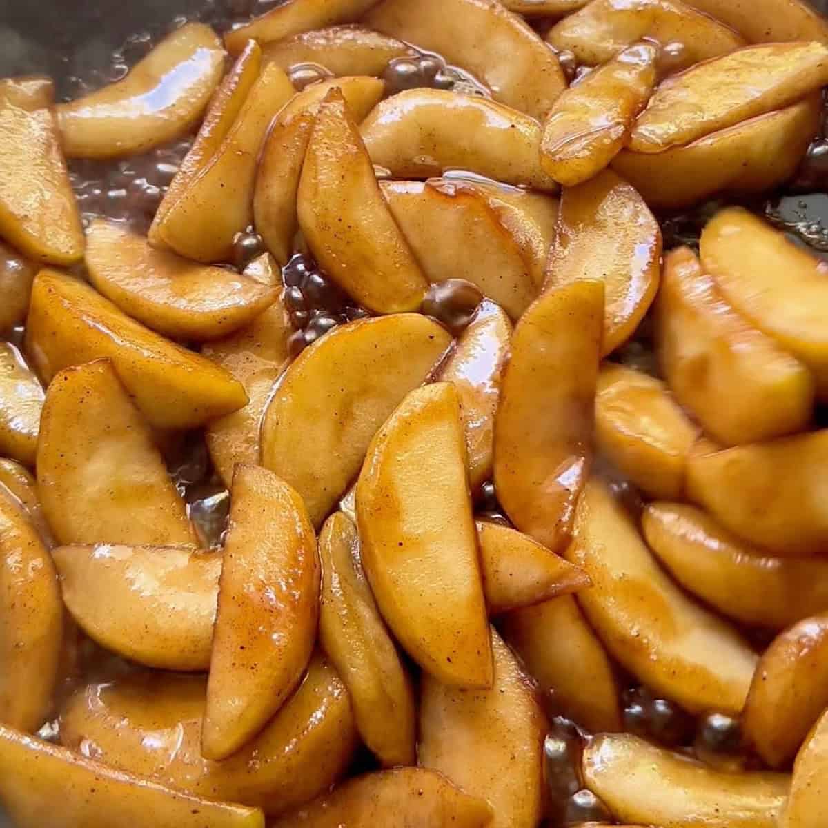 Caramelized apple slices in a skillet.