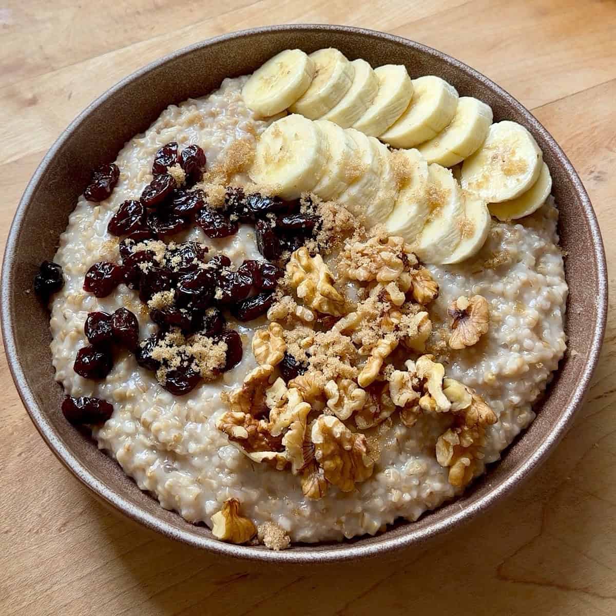 Steel cut oats in a bowl with fruit and nut toppings.