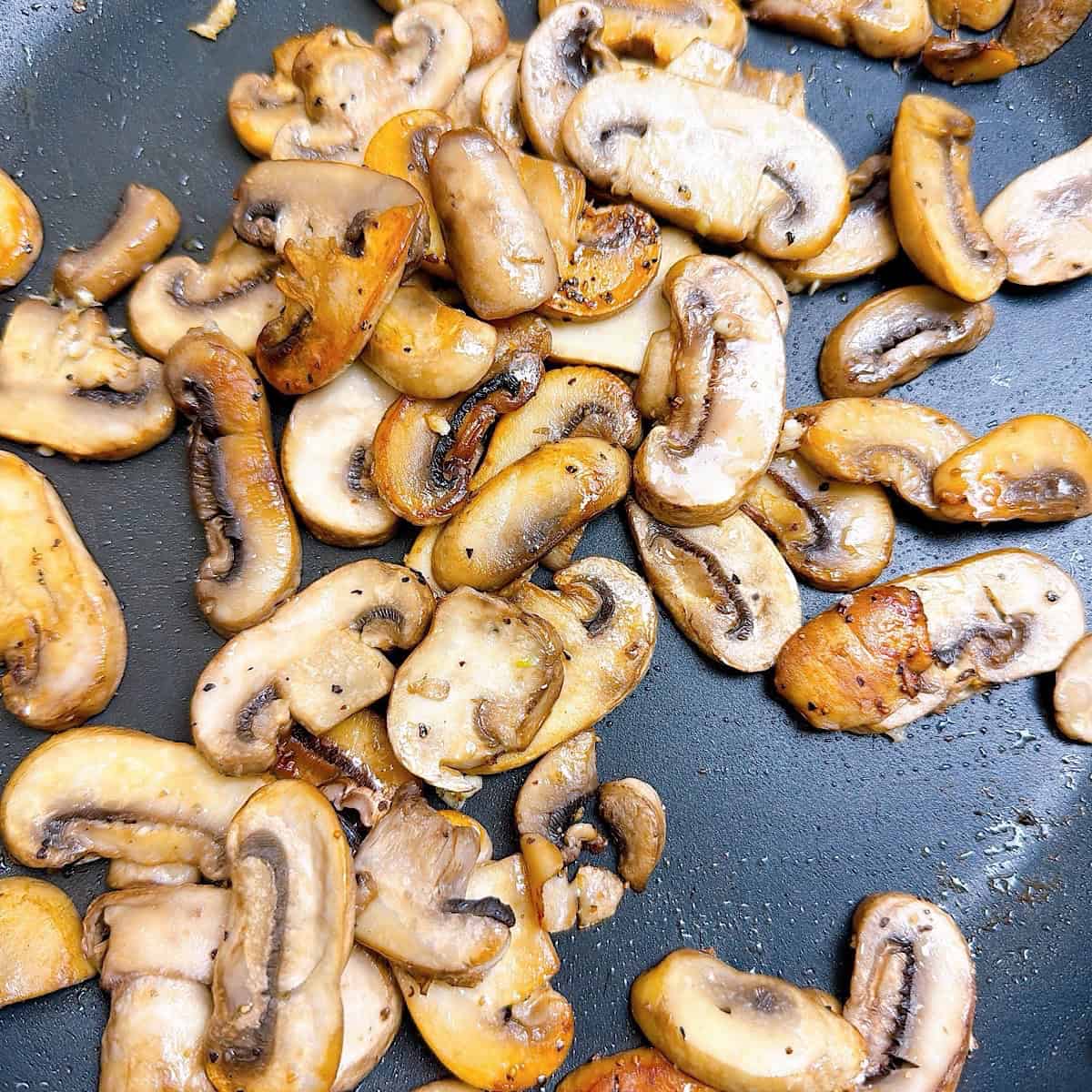Prepared mushrooms with garlic in a skillet.