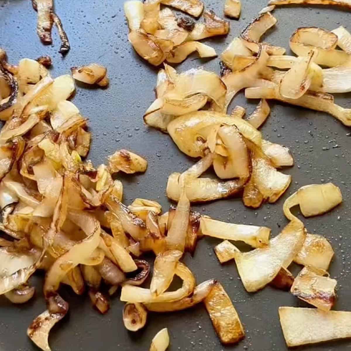 Caramelizing sliced onions in a skillet.