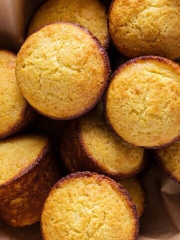 Sweet southern cornbread muffins in a bowl with parchment.