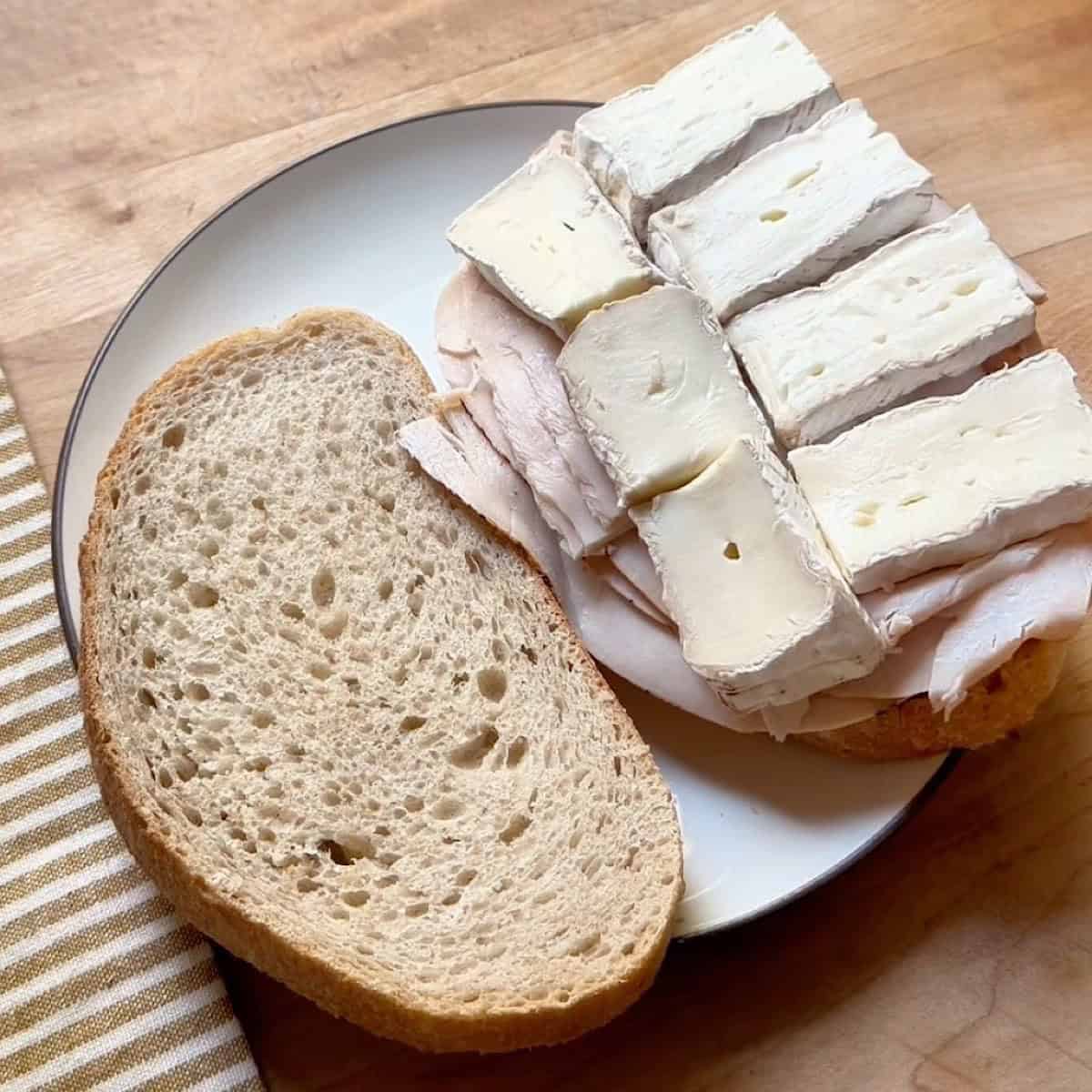 Open face artisan bread layered with cranberry sauce, turkey, and brie cheese.