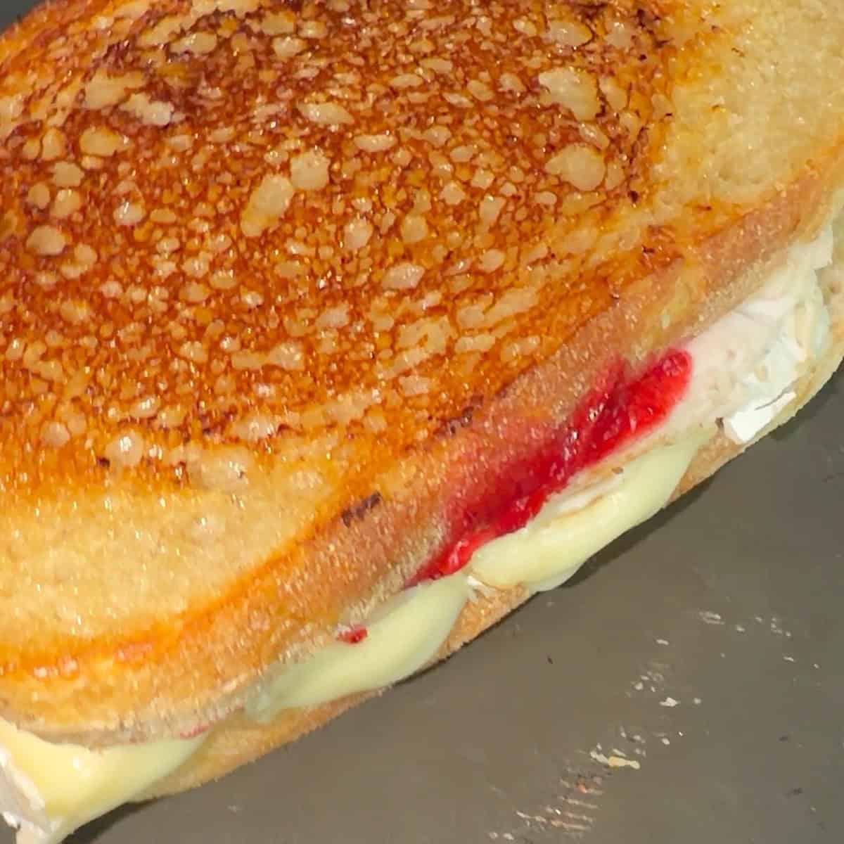 Toasting the turkey brie cranberry sandwich in a skillet.