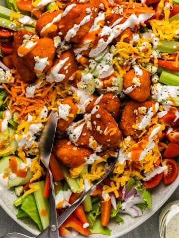 Buffalo chicken salad platter with buttermilk ranch dressing drizzled over top.