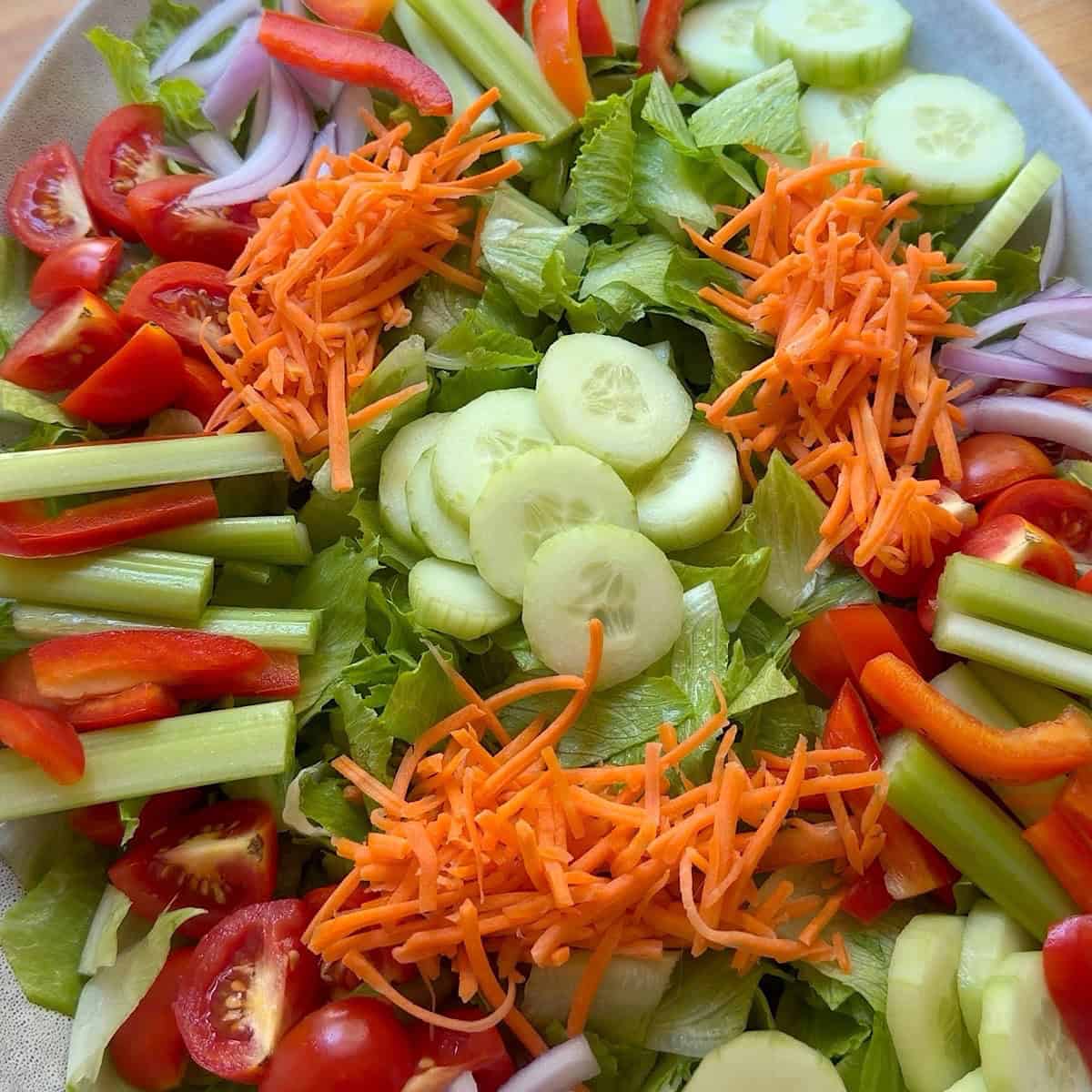 Romaine lettuce base with veggies arranged on a platter.
