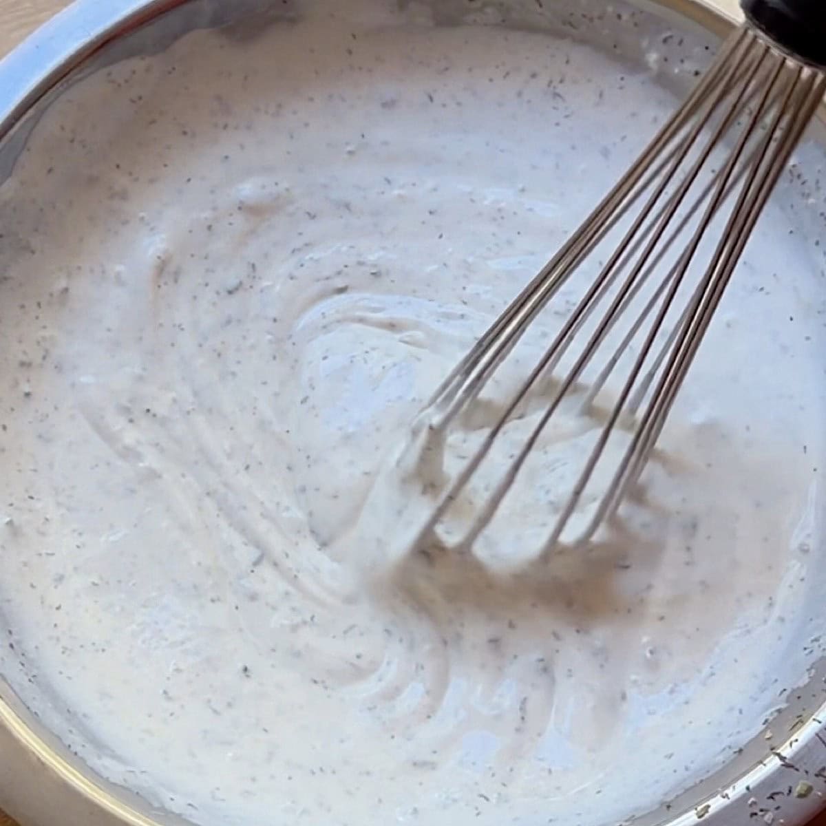 Whisking the buttermilk dressing.