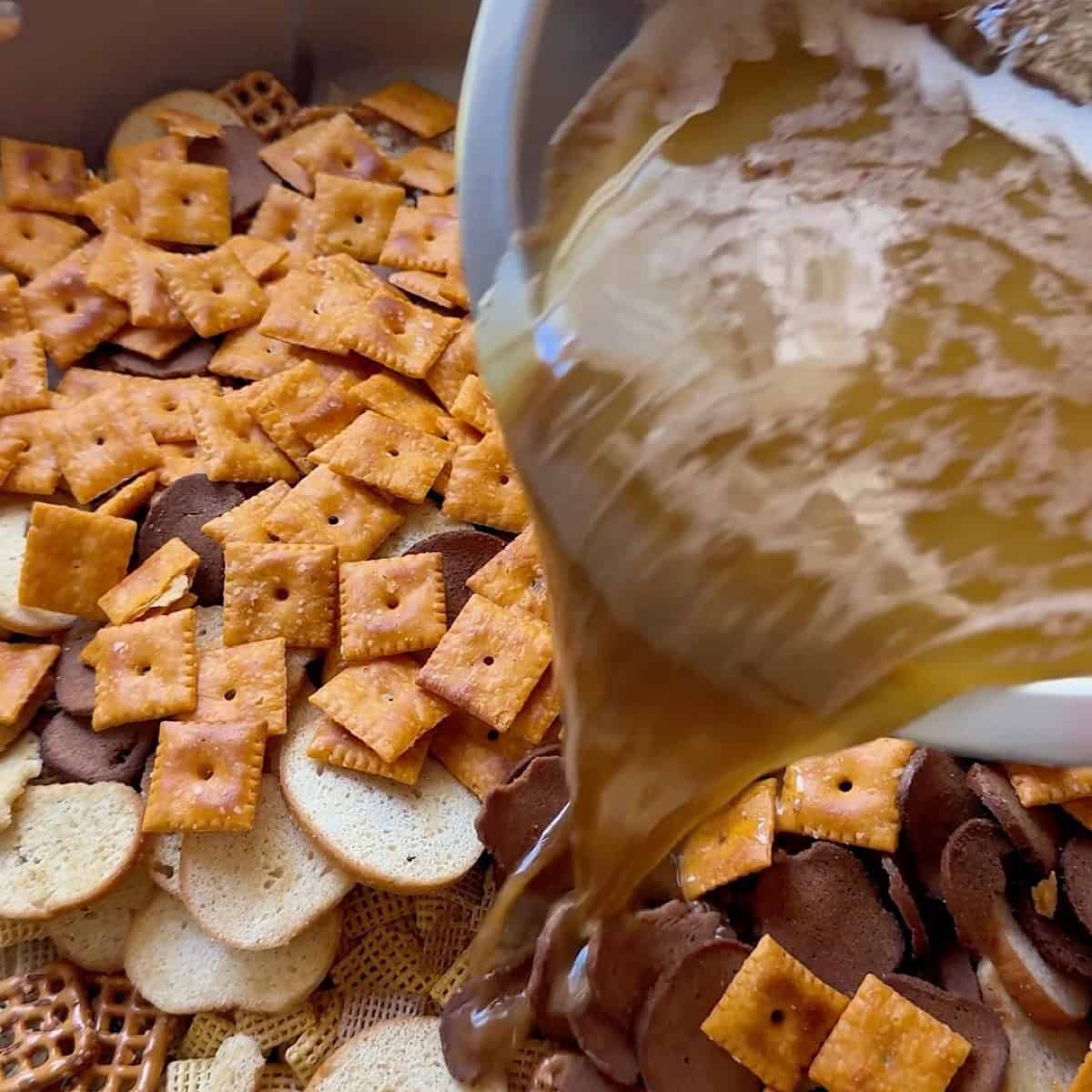 Coating the Chex Mix with the butter and seasonings.