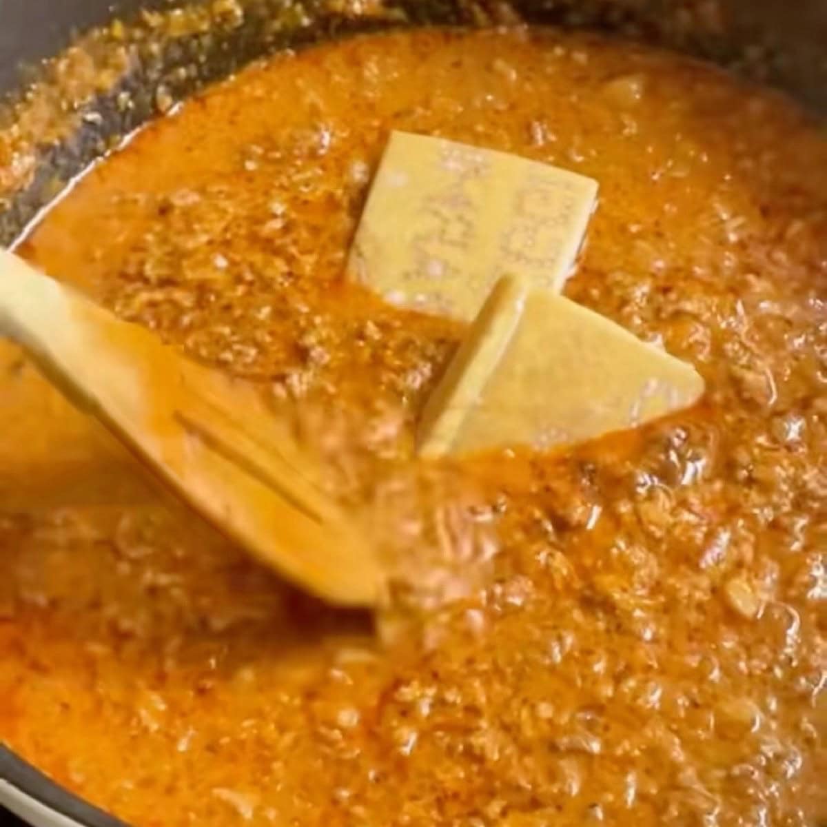 Combining the bolognese sauce ingredients and adding parmesan rind.