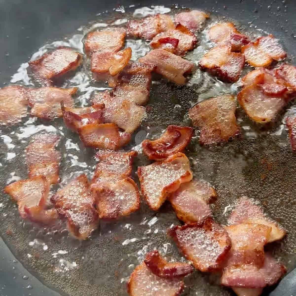 Bacon frying in a skillet.