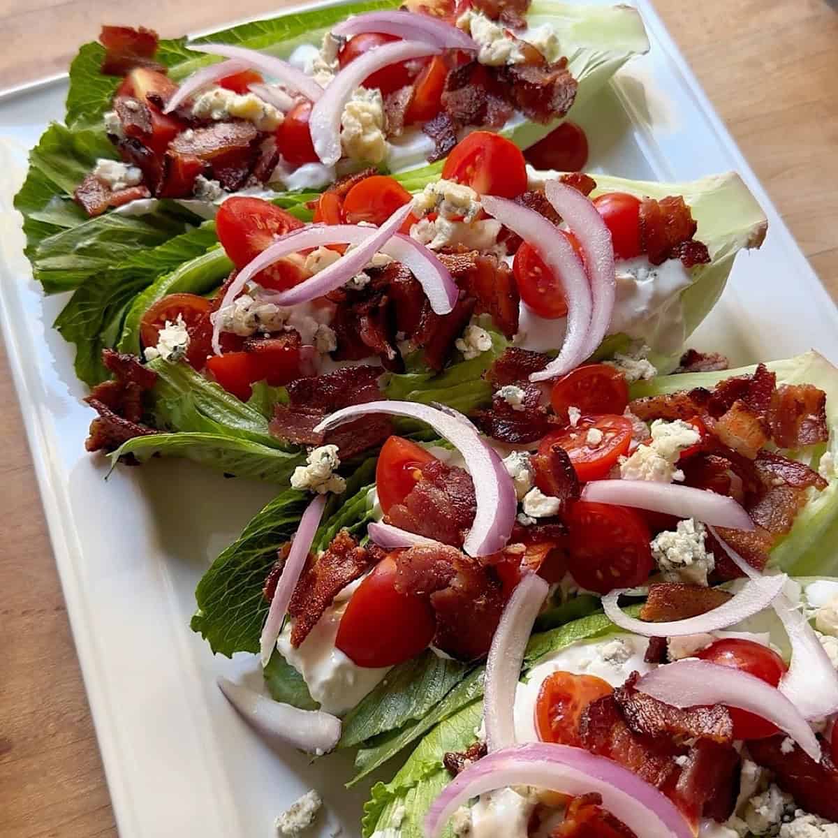 Blue cheese wedges with bacon, tomato, red onion, and blue cheese crumbles topping.