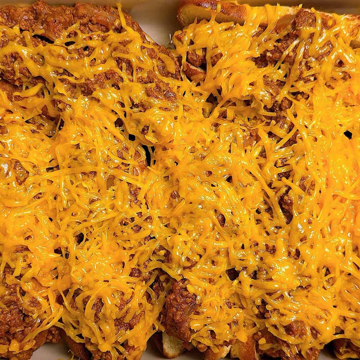 Melted cheese over the chili cheese hot dogs.