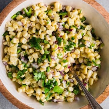 Copycat Chipotle corn salsa with toppings in a decorative bowl.