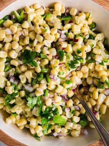 Copycat Chipotle corn salsa with toppings in a decorative bowl.