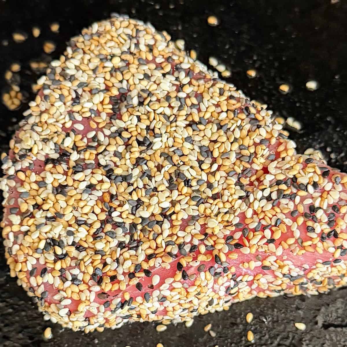 Ahi tuna searing in skillet over med-high heat.