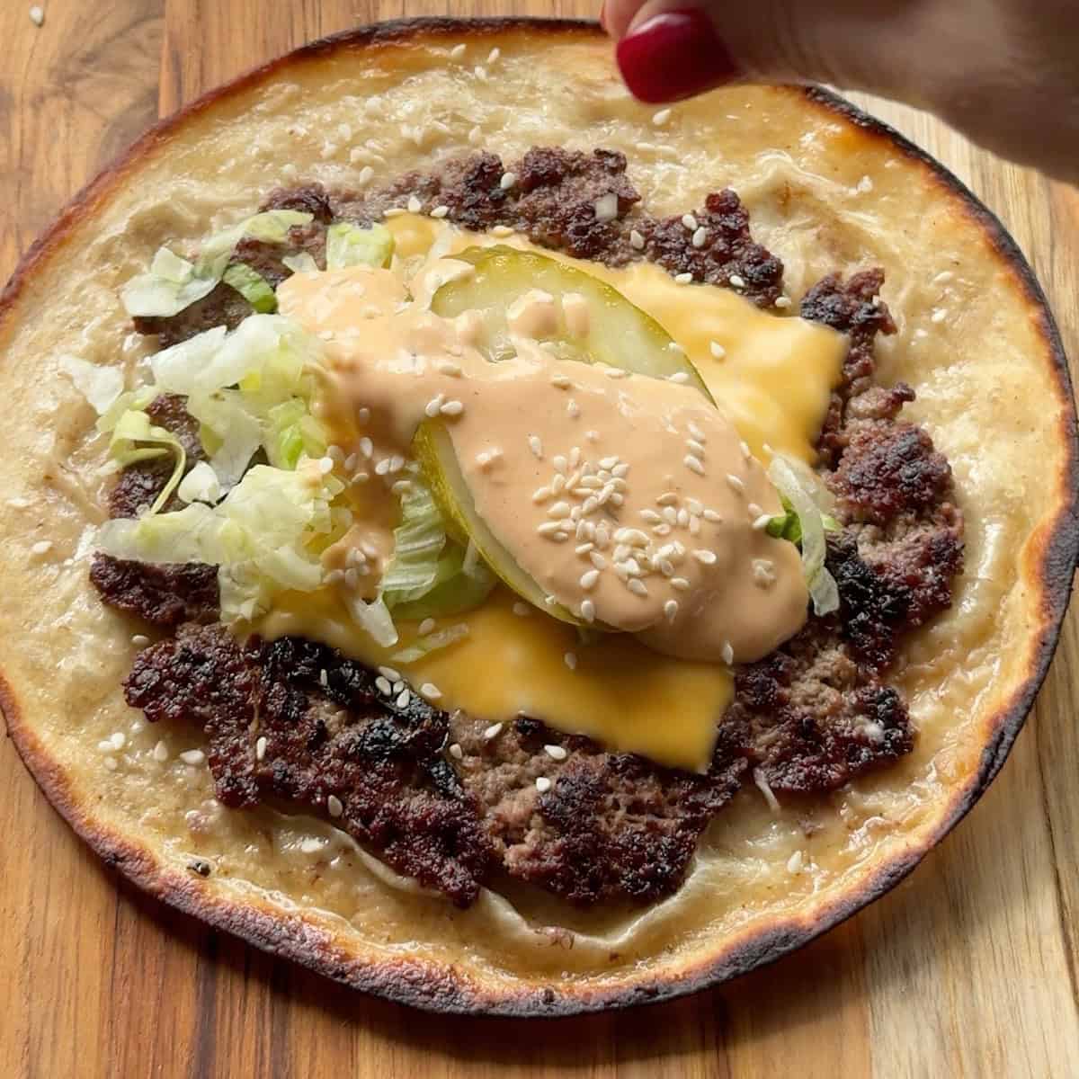 Big Mac taco fully assembled with toppings and ready to fold.