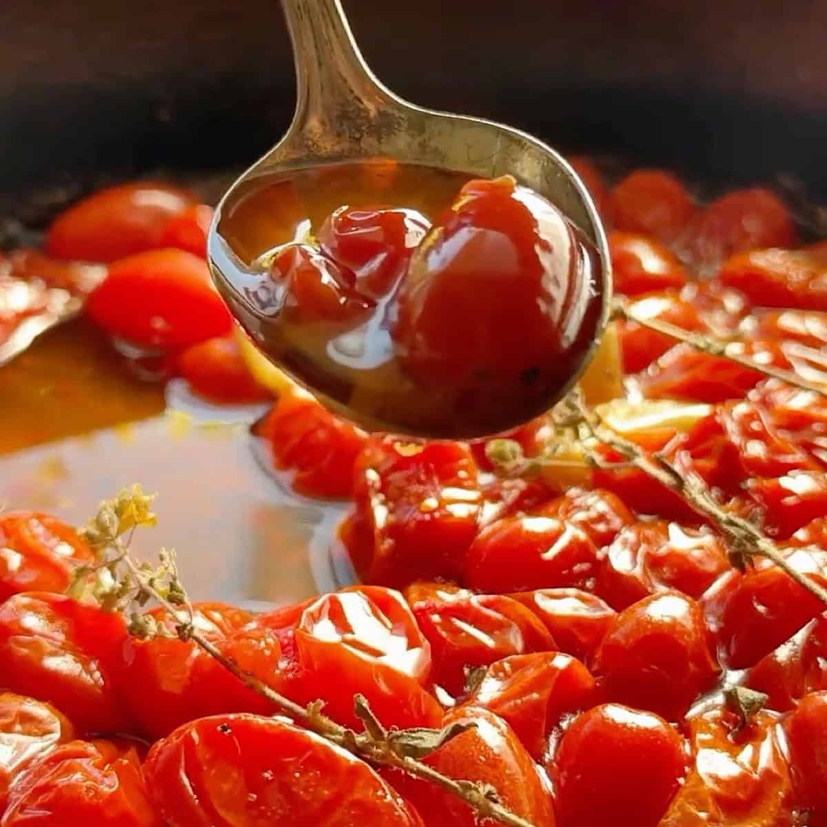A spoonful of tomato confit dripping into the skillet.