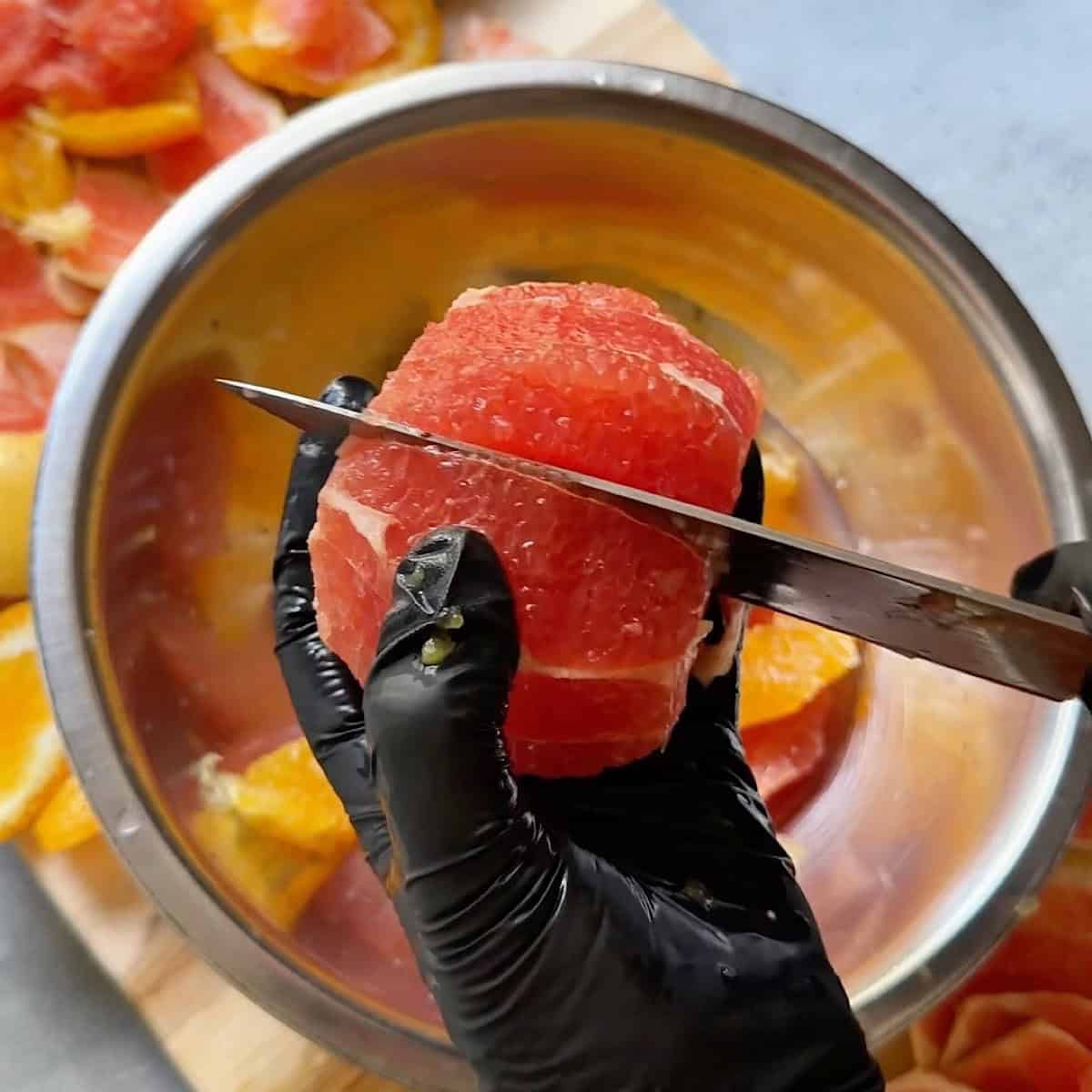 Preparing the grapefruit by sectioning and removing the pith.