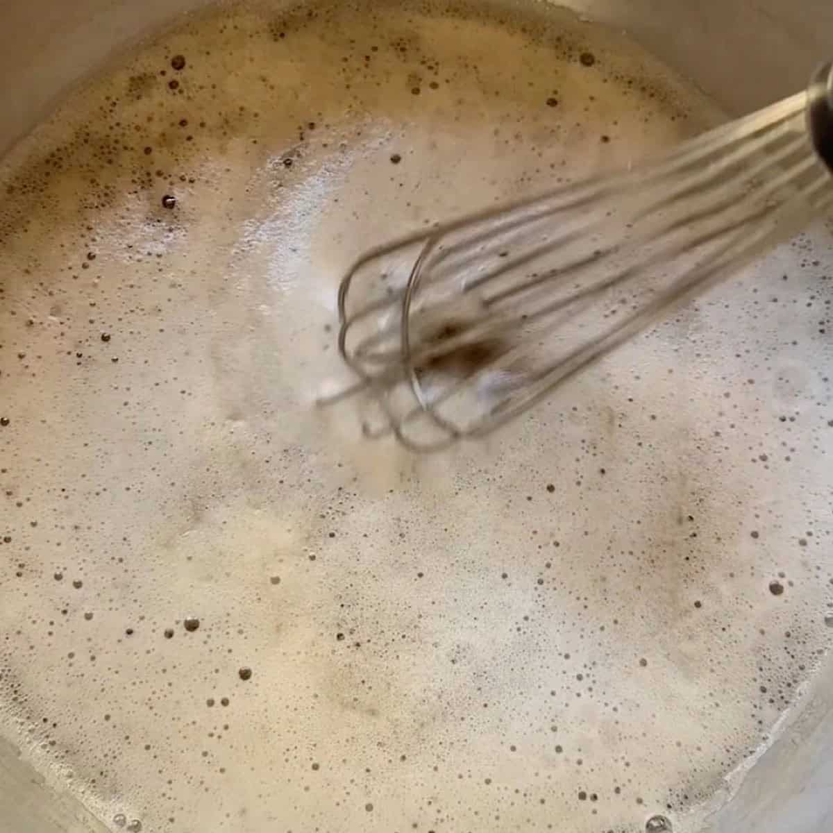 Whisking the lager beer with the sodium citrate.