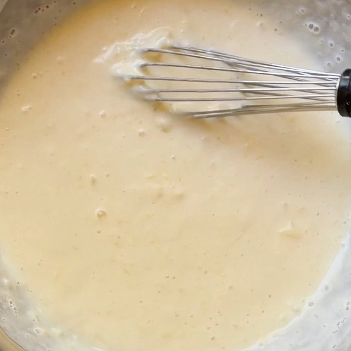 Wet pancake ingredients whisked in a bowl.
