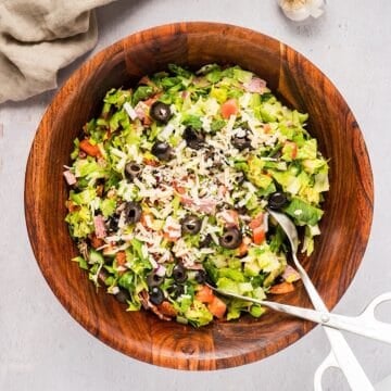 Chopped Italian Grinder Style Salad in a wooden bowl with serving utensil.