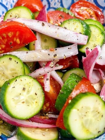 Southern Cucumber Tomato and Onion Salad in a blue decorative bowl.