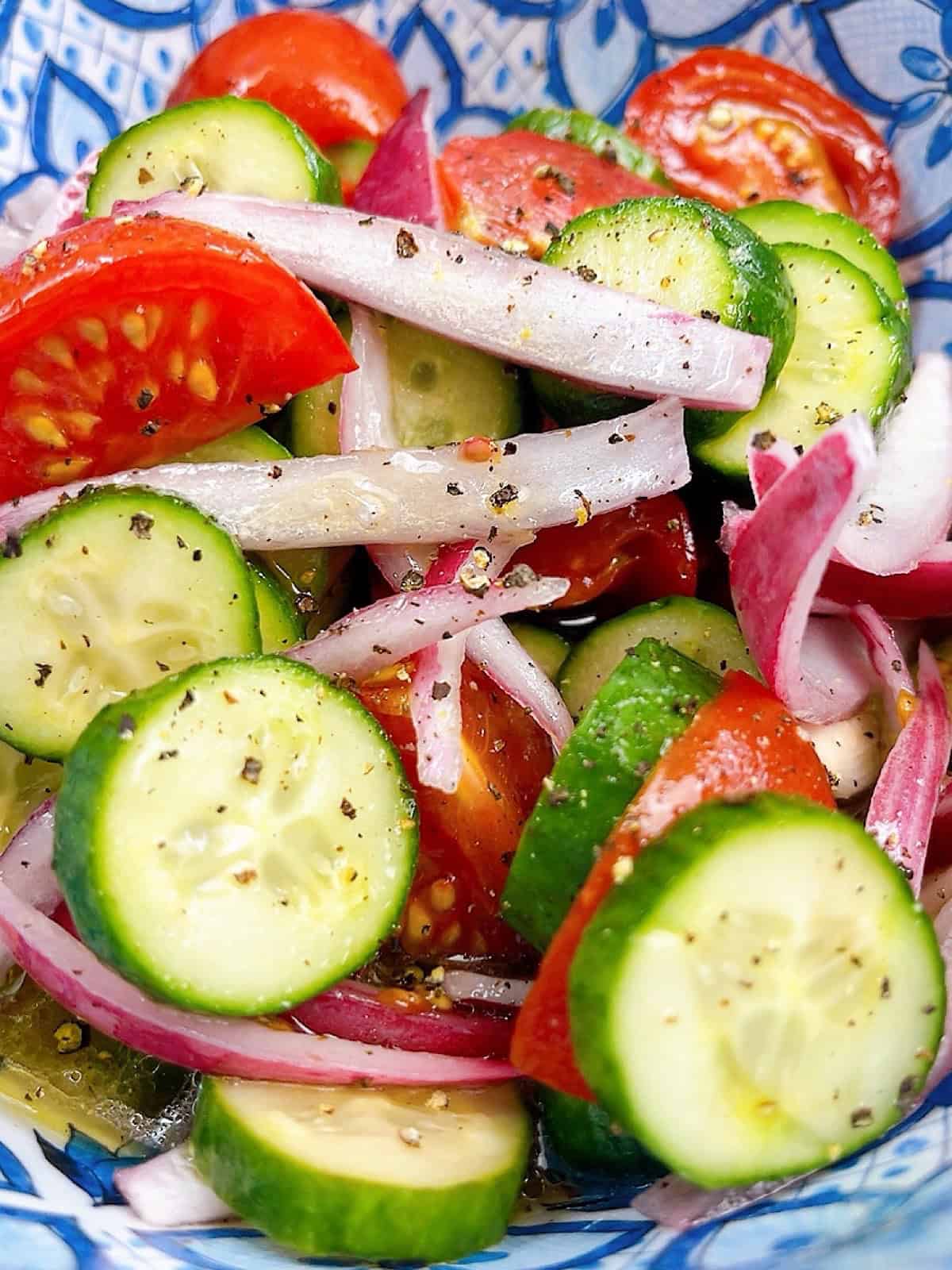 Southern Cucumber Tomato and Onion Salad in a blue decorative bowl.