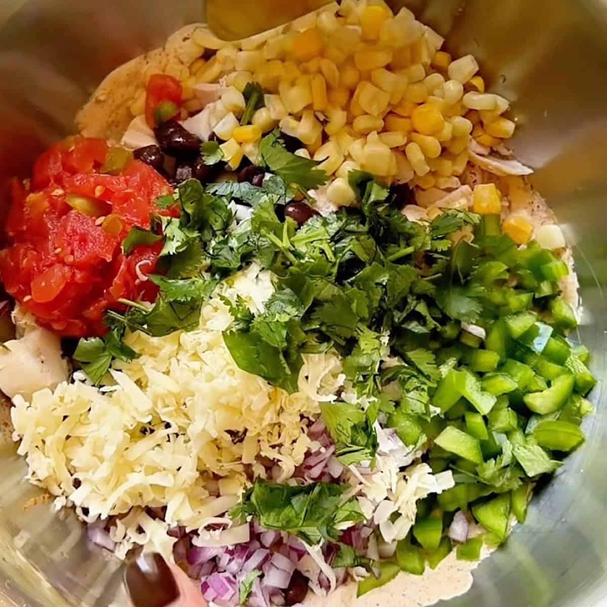 All southwest chicken salad ingredients layered in a bowl.