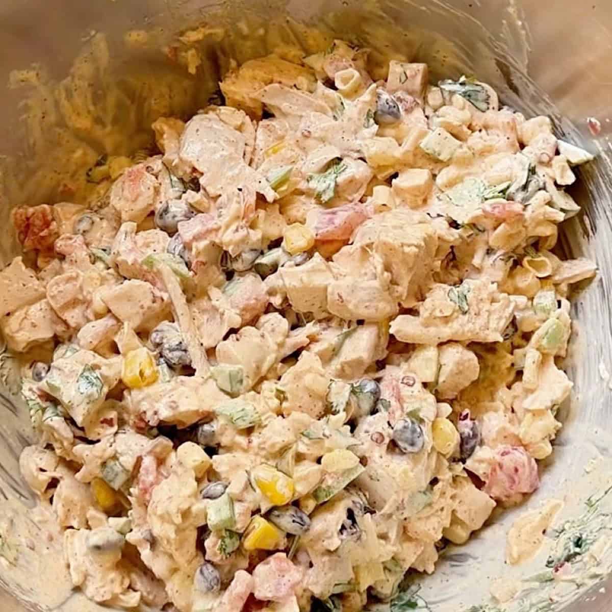 Southwest chicken salad tossed with dressing and ready to refrigerate.