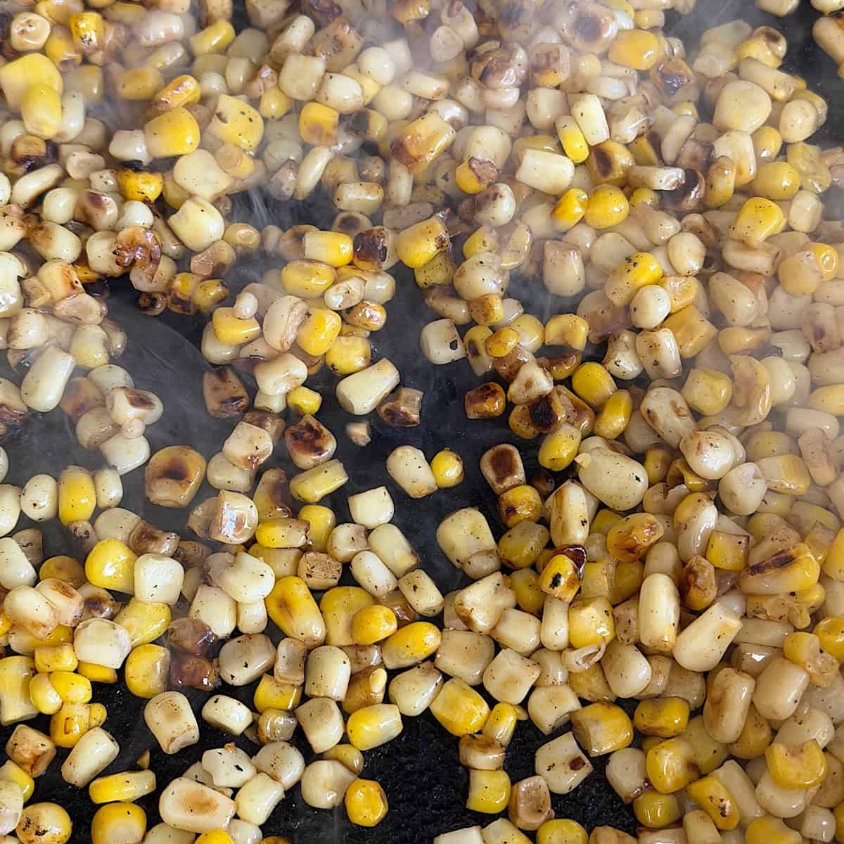 Charred corn in a cast iron skillet.