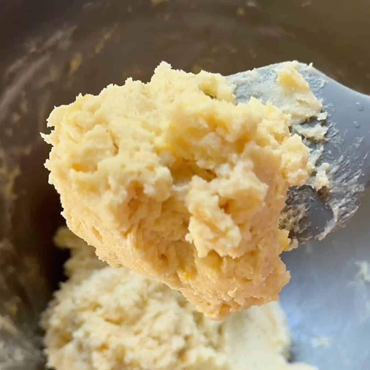 Spatula showing consistency of lemon ricotta cookie batter.