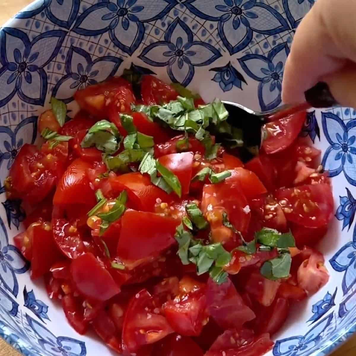 Combining the diced tomatoes with fresh basil and garlic.
