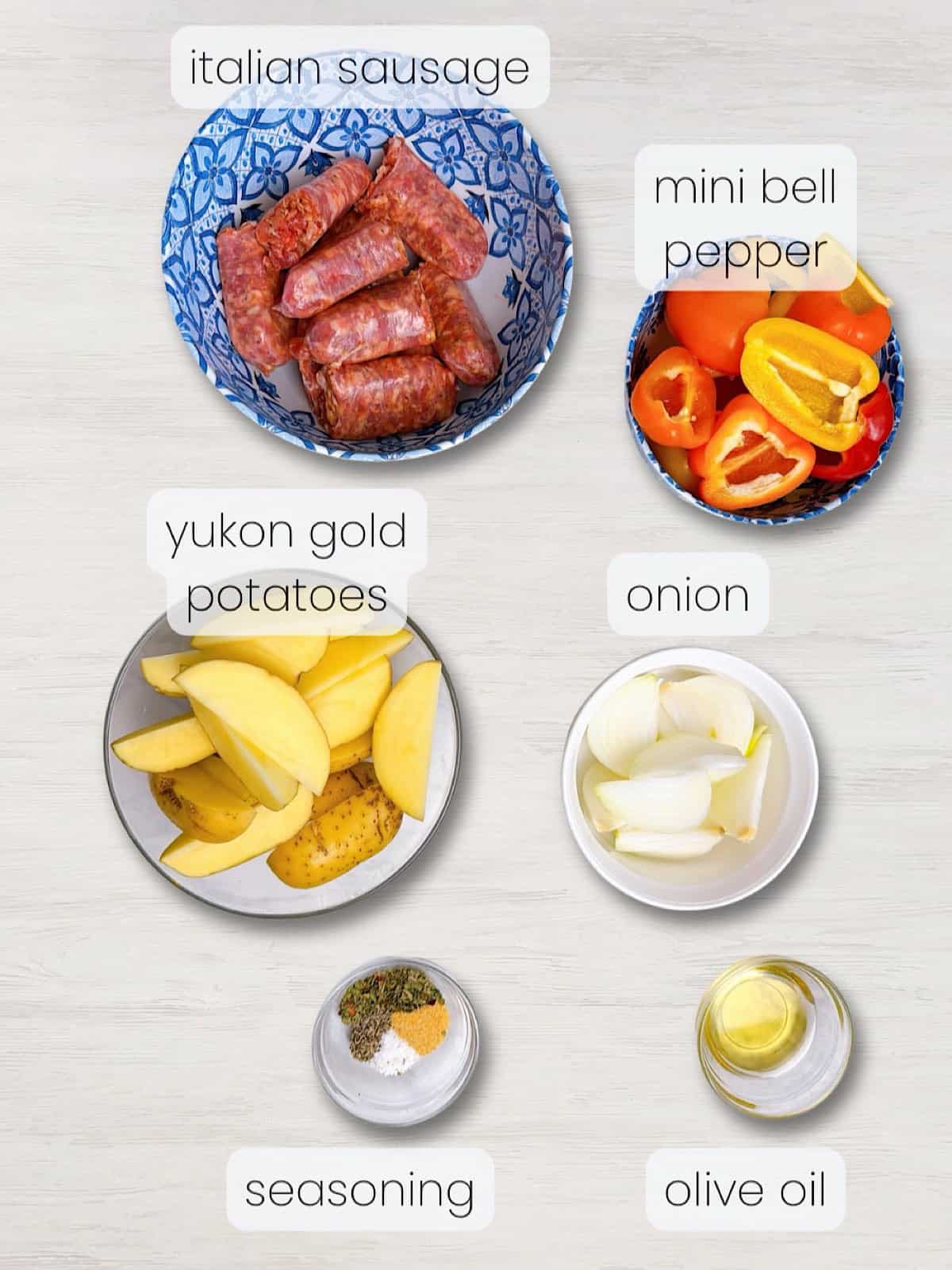 A labeled image of everything needed to make sheet pan italian sausage and potatoes with peppers.