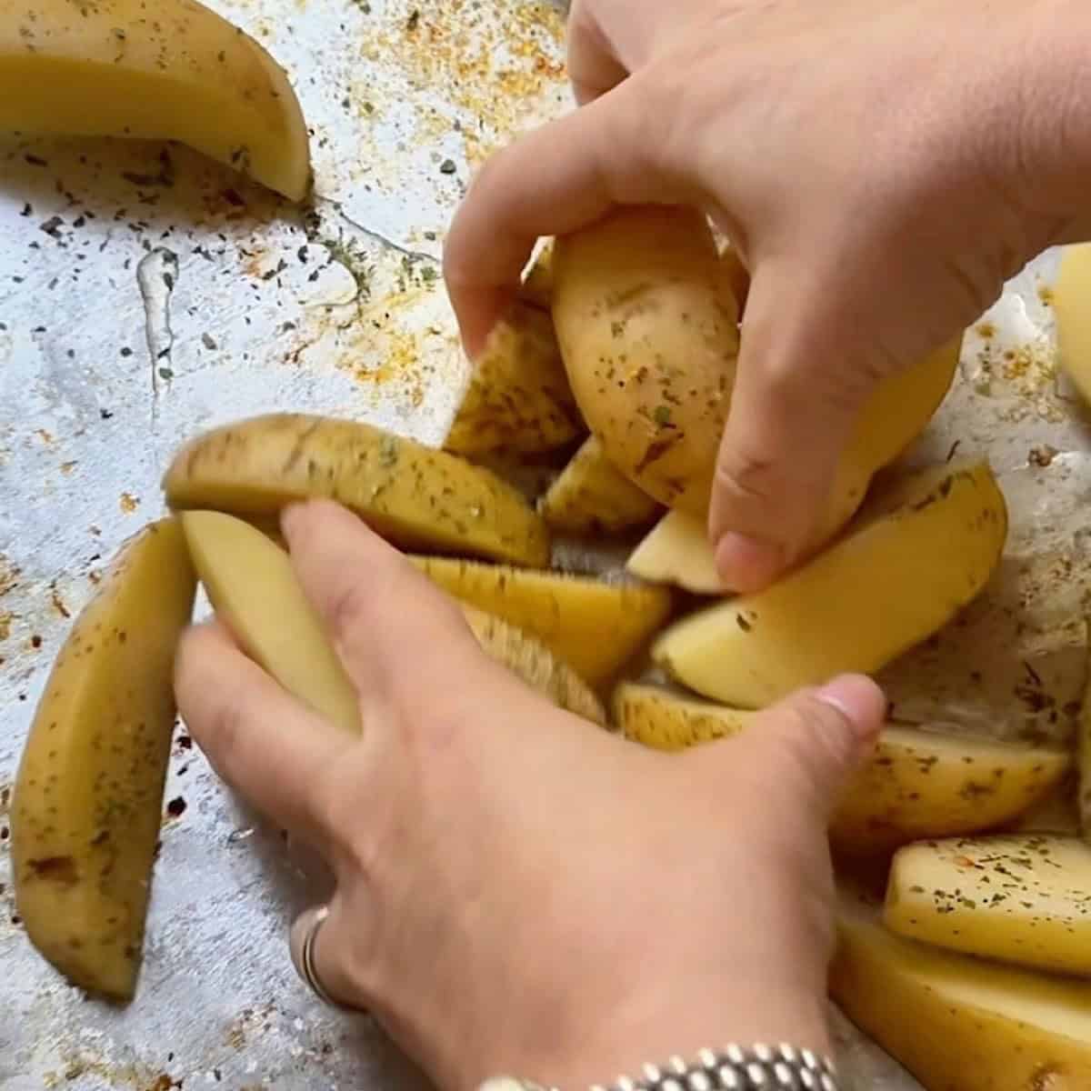 Tossing the potatoes with olive oil and seasoning.