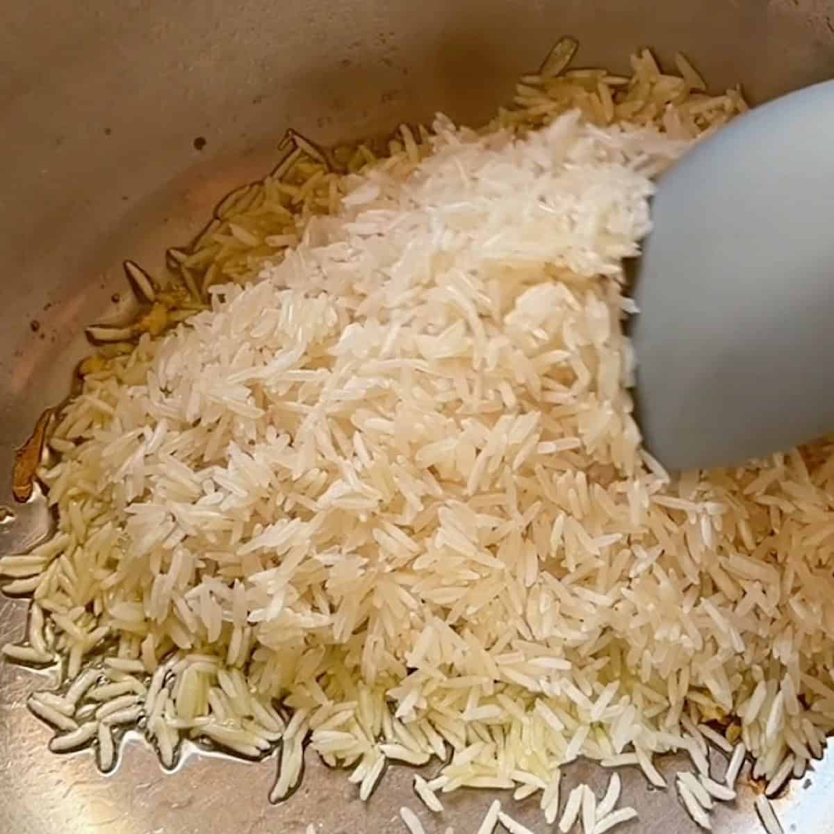 Toasting the basmati rice in oil and minced garlic.