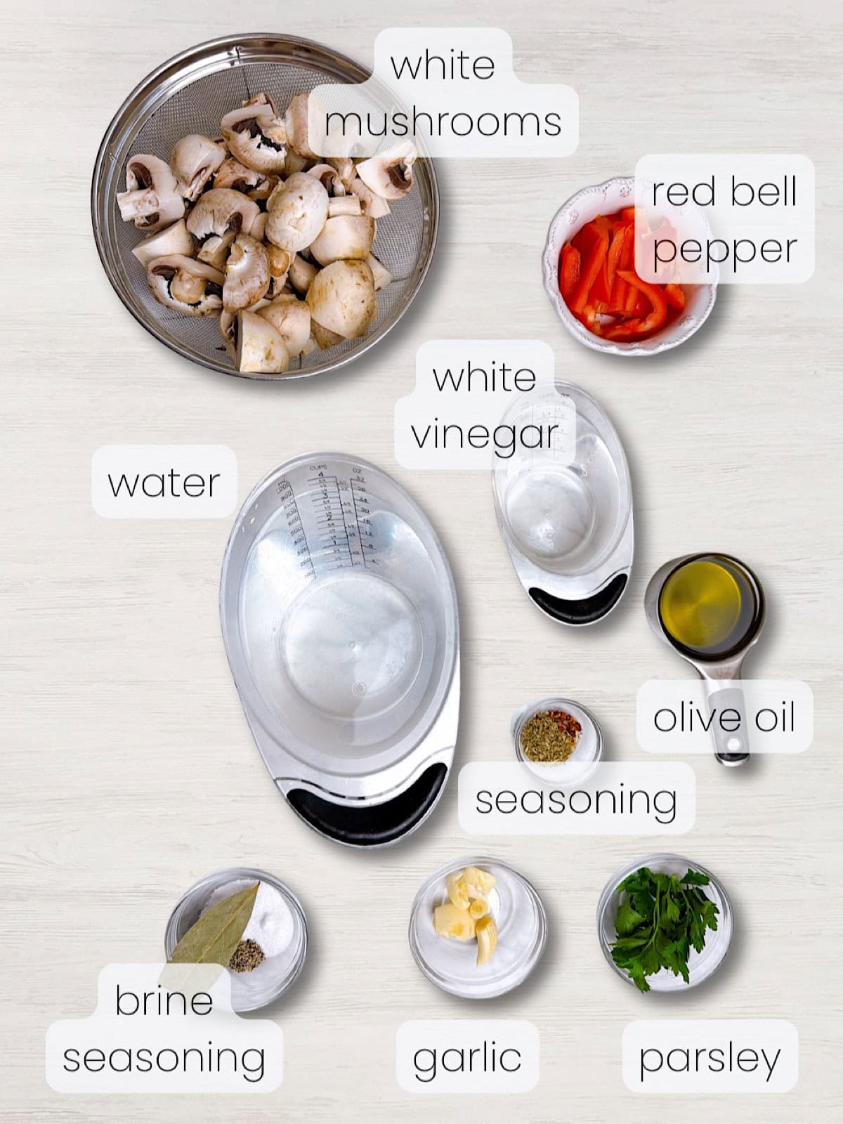 A labeled image of everything needed to make Italian marinated mushrooms.