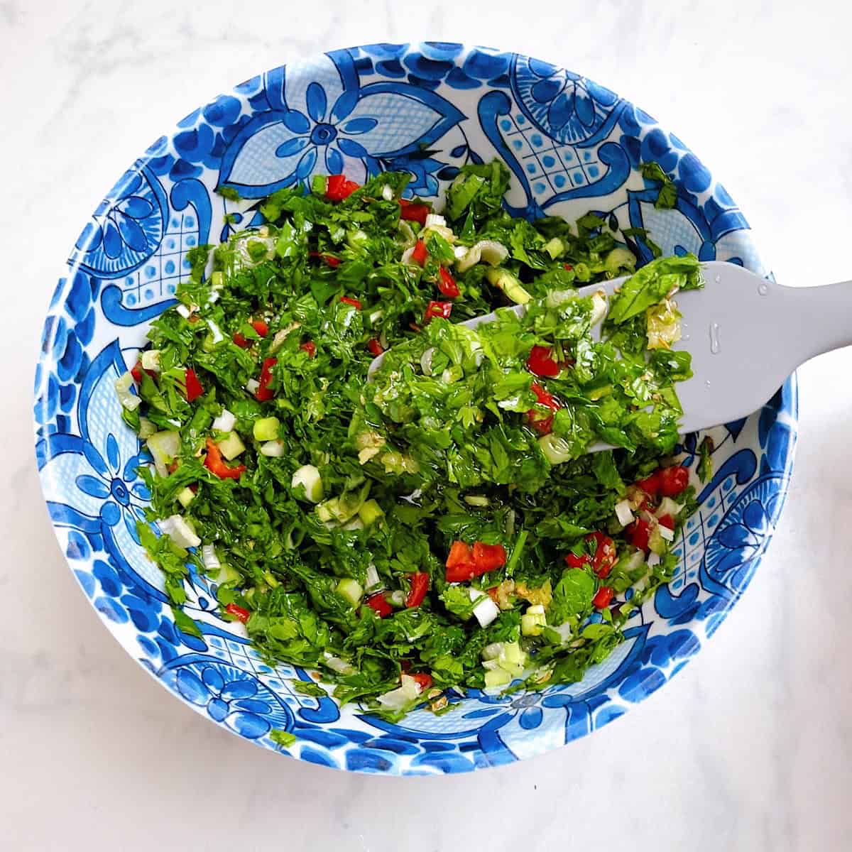 Chimichurri sauce in a bowl, mixed.