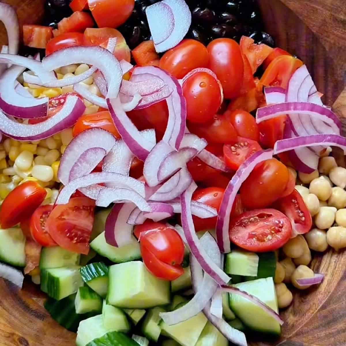 Steak and vegetables added to a salad bowl.