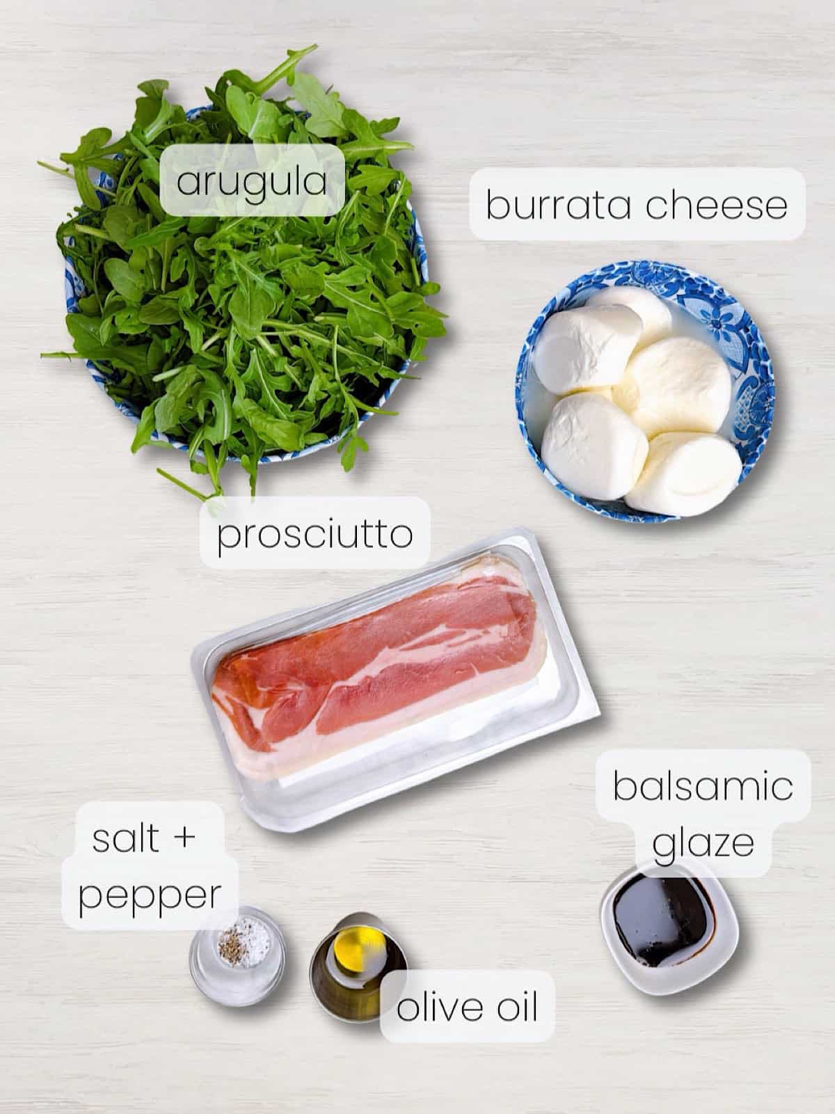 Everything ingredient needed to make a burrata prosciutto appetizer or salad.
