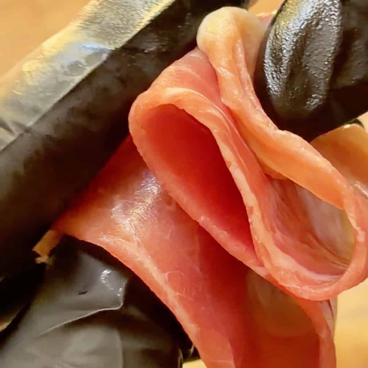 A piece of prosciutto folded into a ribbon.