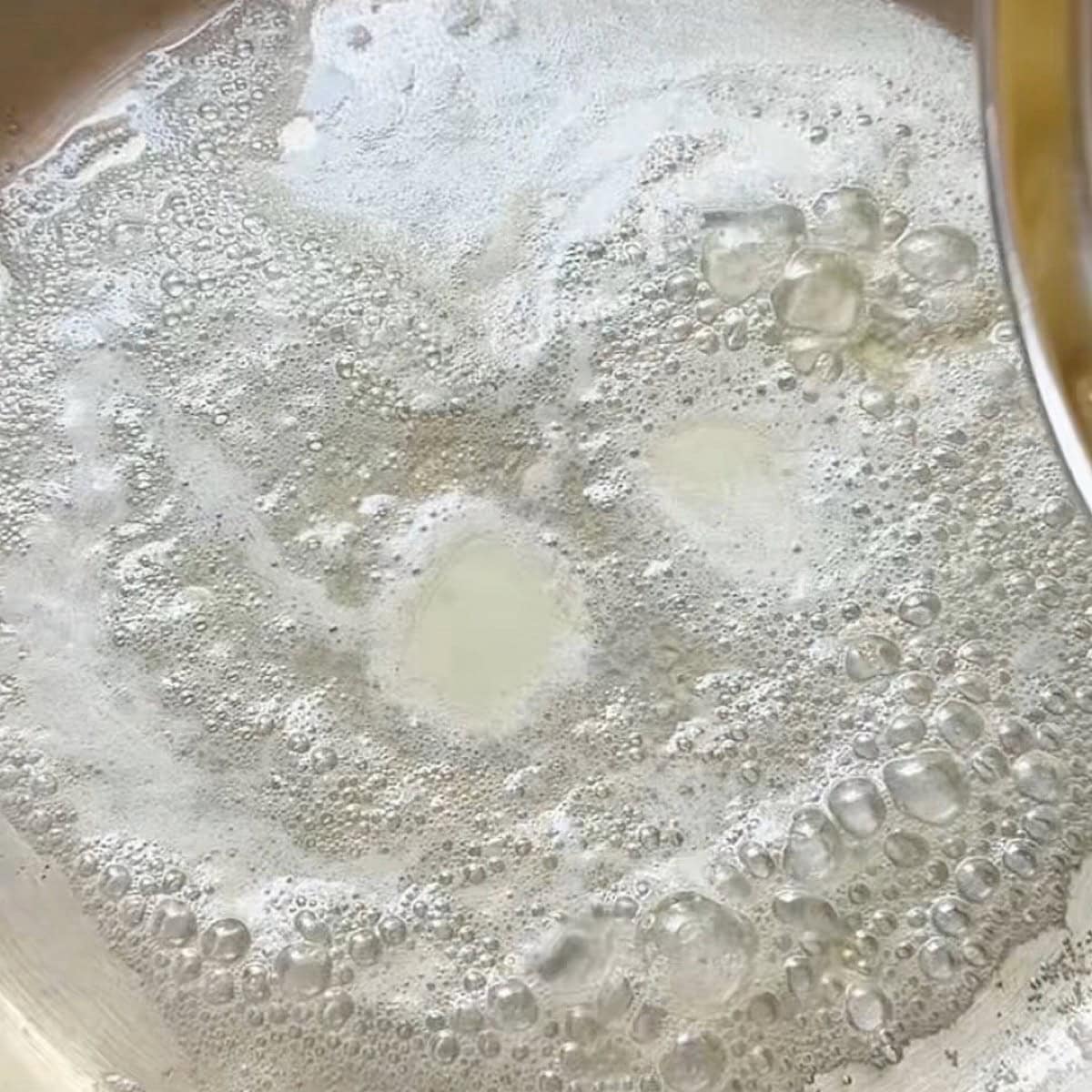 Melted butter foaming in a skillet.