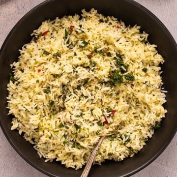 Chimichurri rice in a black bowl with parsley showing on top.