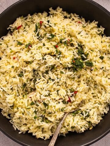 Chimichurri rice in a black bowl with parsley showing on top.