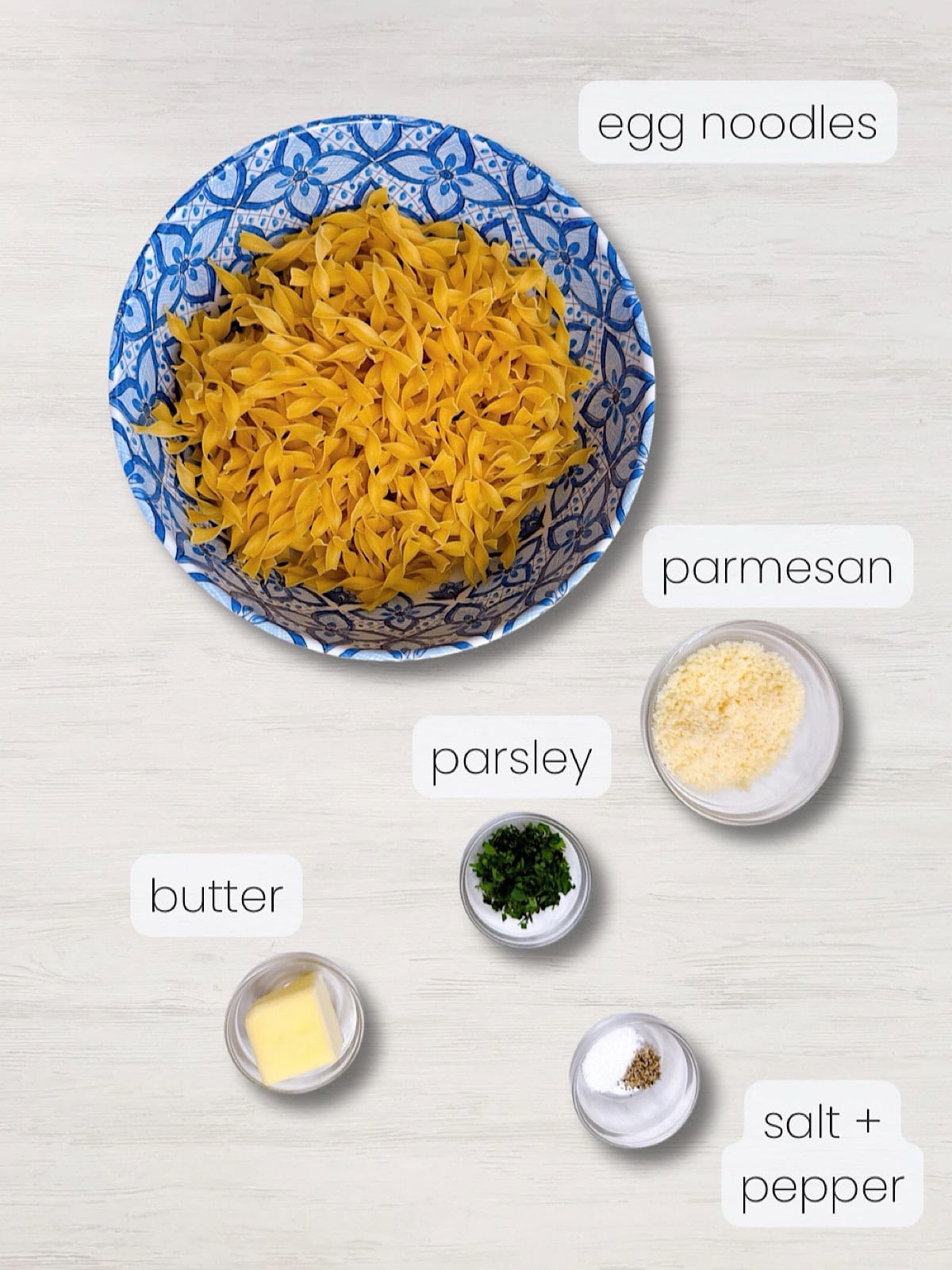 A labeled image of everything needed to make buttered egg noodles with parmesan.
