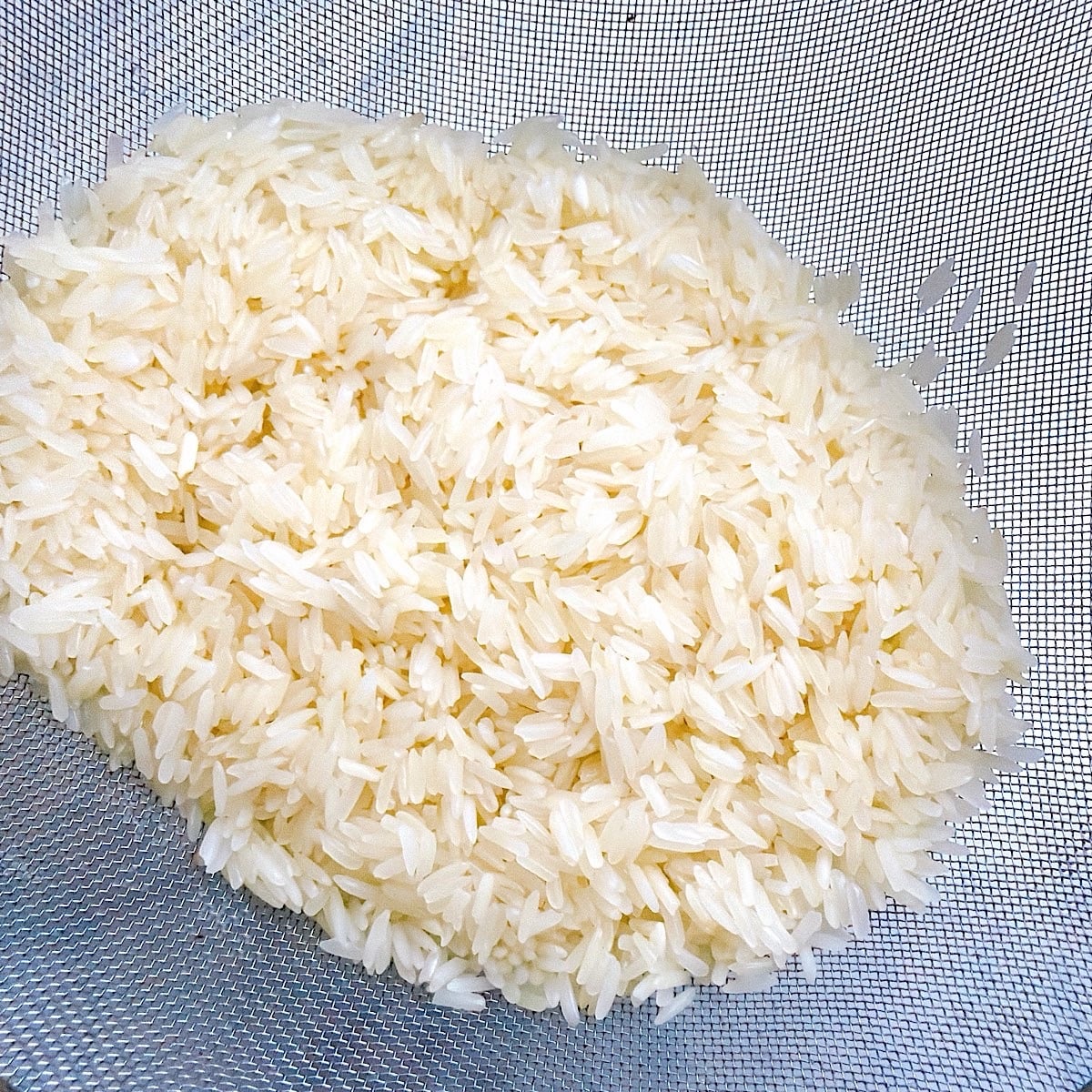 Rinsed jasmine rice being strained.