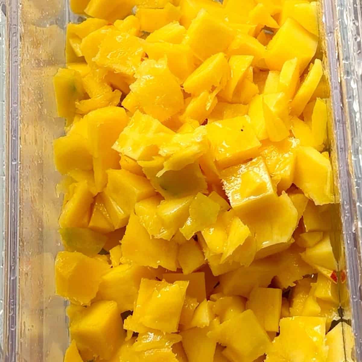 Diced mango in a clear container.
