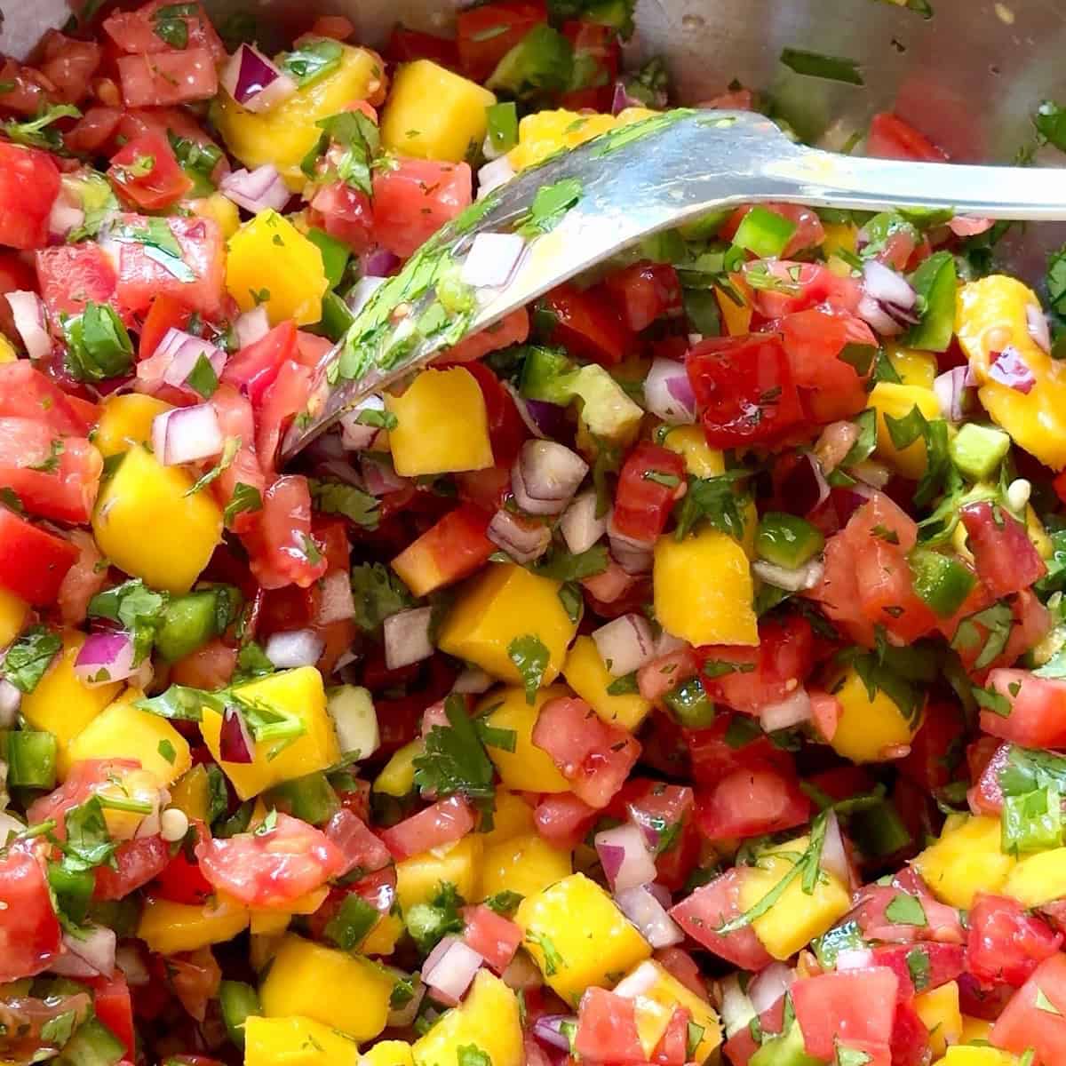Mango pico de gallo tossed togeher in the mixing bowl.