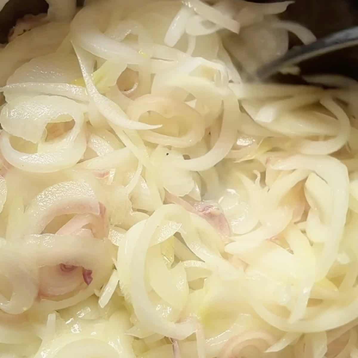 Onions and shallots cooking with oil and butter in a dutch oven.